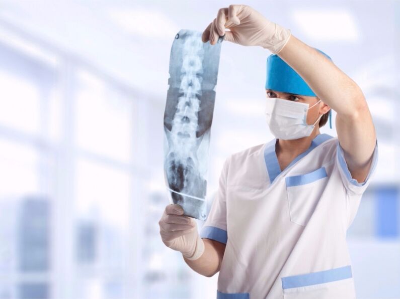 the doctor looks at a snapshot of the cervical spine for osteochondrosis