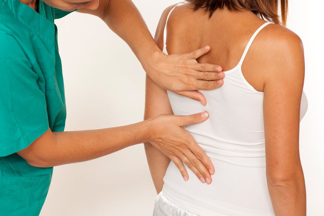 the doctor examines the back pain in the shoulder area